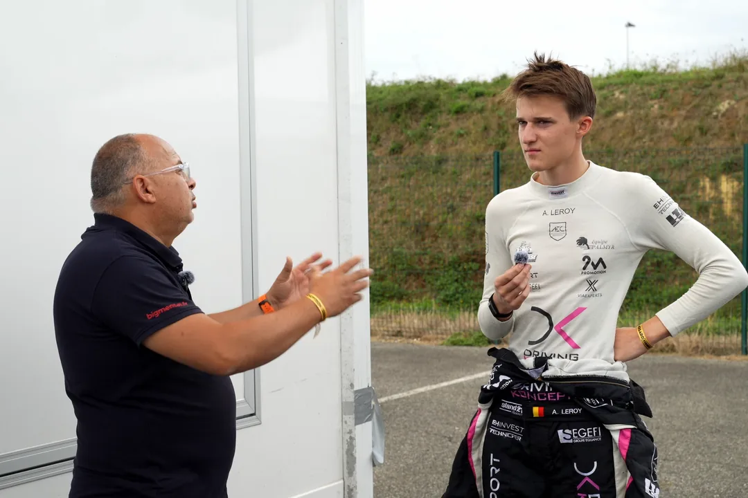 Dominique Palanque en pleine explication avec un jeune pilote en combinaison, dans le paddock